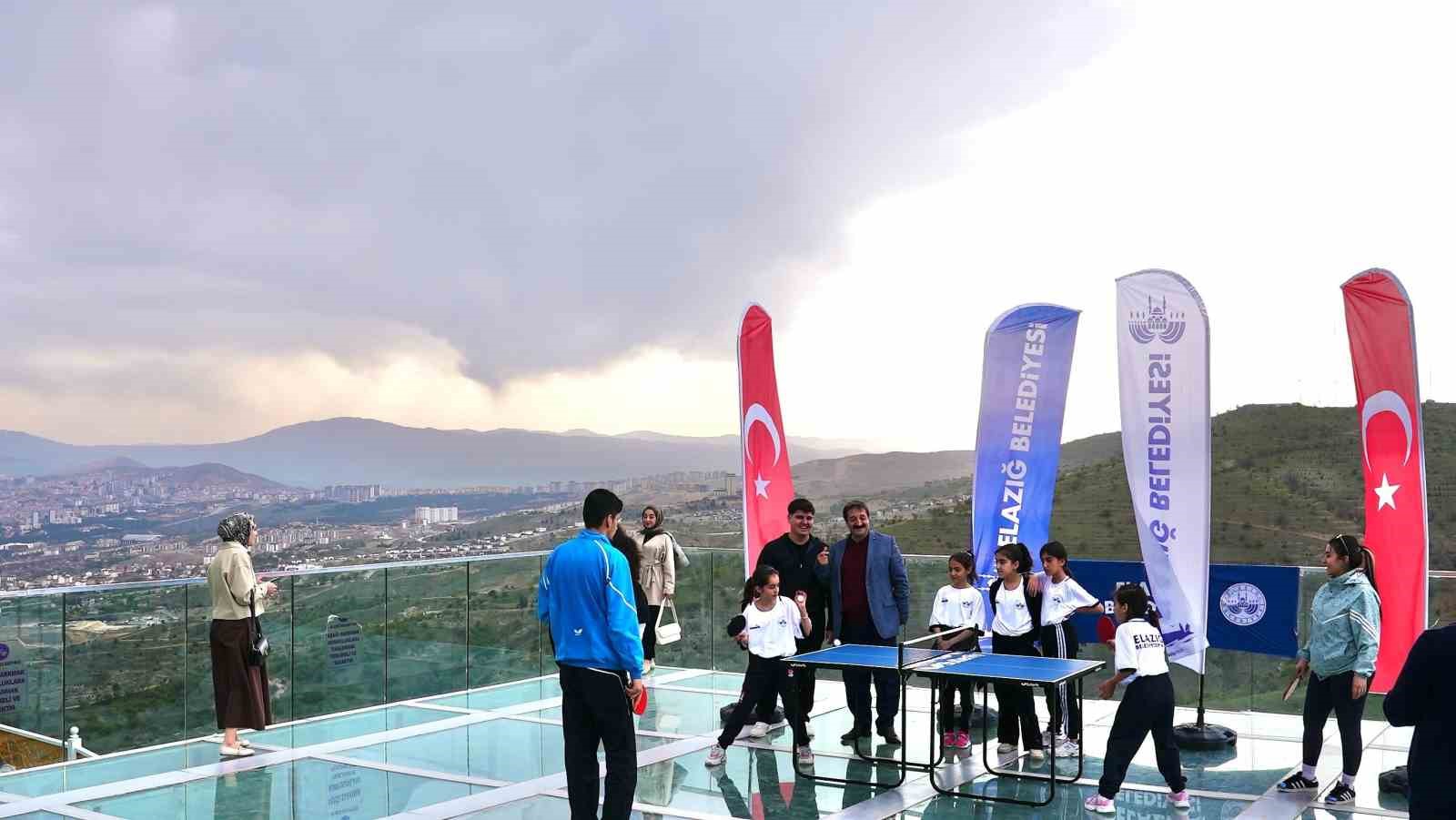 Cam teras üzerinde masa tenisi karşılaşması, renkli görüntüler oluşturdu
