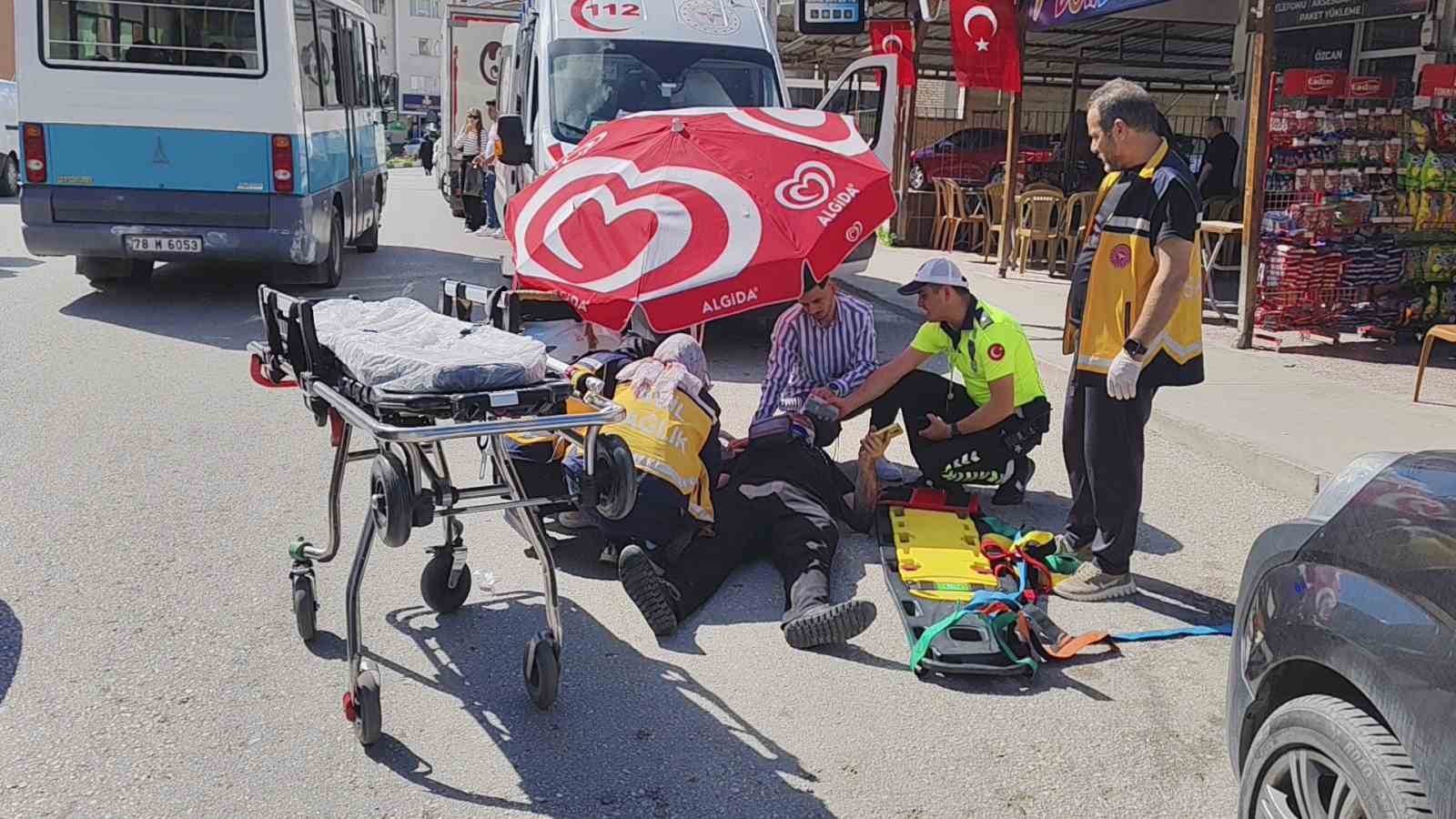 Motosiklet kazasında yaralanan yayayı güneşten şemsiye yardımıyla korudular
