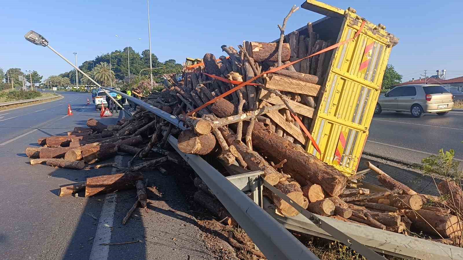 Tomruk yüklü kamyon bariyerleri aşıp refüje devrildi