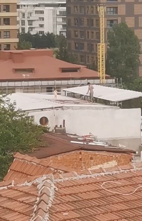 Çocukla birlikte çatıda halı yıkayan vatandaş kamerada
