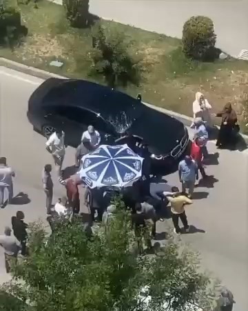 Vatandaşlar yerdeki yaralıyı g&uuml;neşten korumak i&ccedil;in dondurma şemsiyesi kullandı
