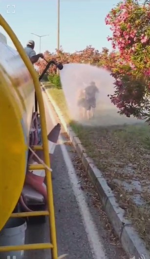 Sıcaktan bunalan çocuklar refüjde sulama yapan su tankeriyle serinledi