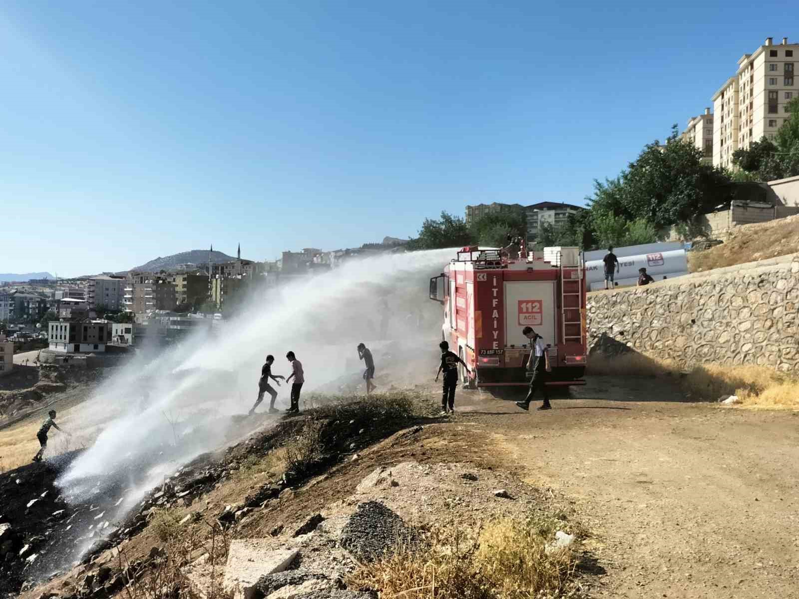 İtfaiyeciler yangın söndürme derdinde, çocuklar serinlemenin keyfinde
