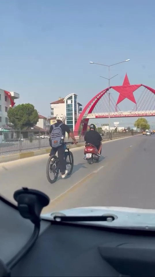 Motosiklete bağladığı iple ana yolda bisikleti çeken sürücü cezasız kalmadı
