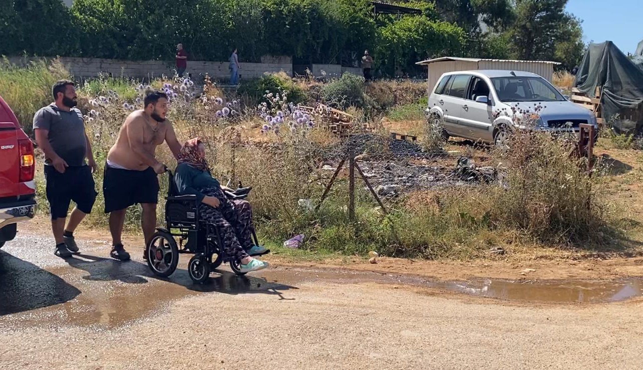 Evine yaklaşan alevlerden kurtarılan kadın tekerlekli sandalyeyle bölgeden uzaklaştırıldı