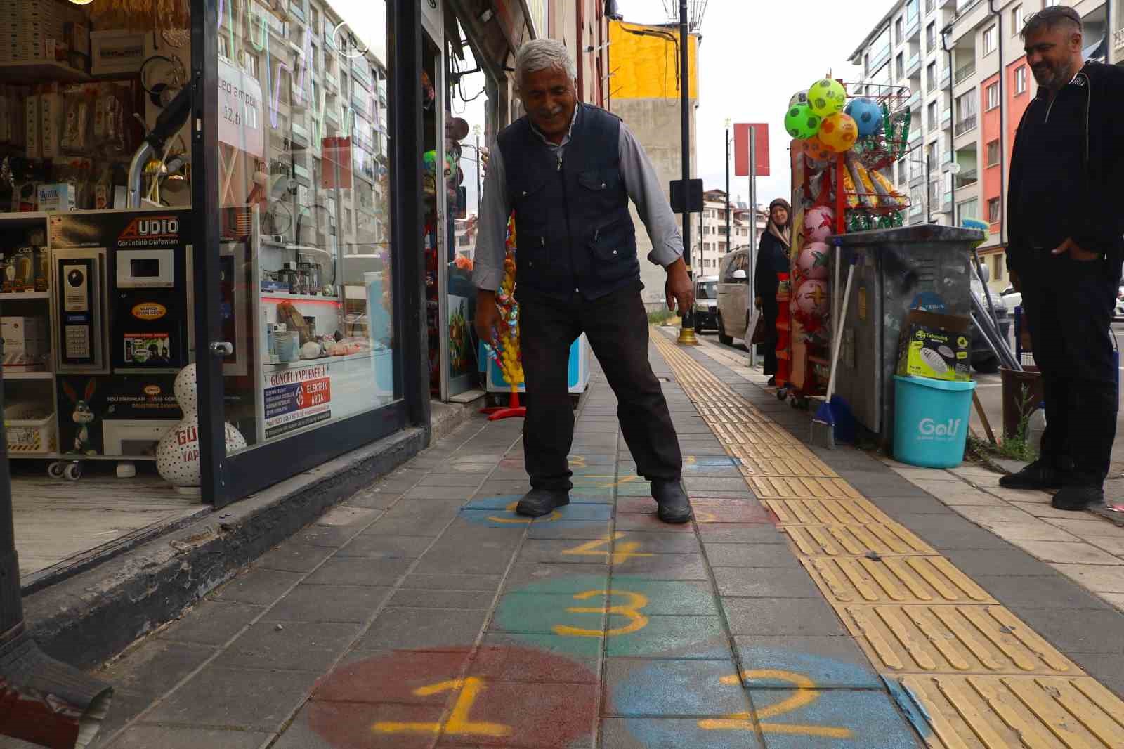 Kaldırıma seksek çizdi, yoldan geçenleri çocukluk hatıralarına götürdü