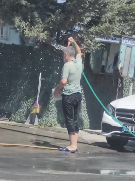 Sultangazi’de sıcaktan bunaldı: Hortumla hem kendini hem de aracını yıkadı