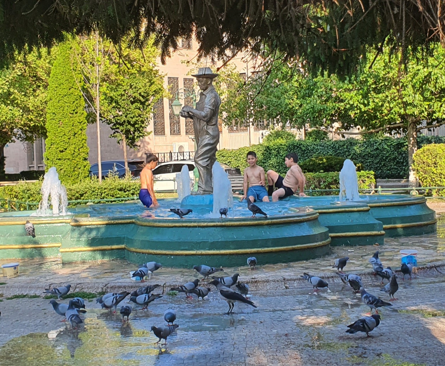 Sıcaklardan bunalan çocuklar süs havuzuna girerek serinlemeye çalıştı