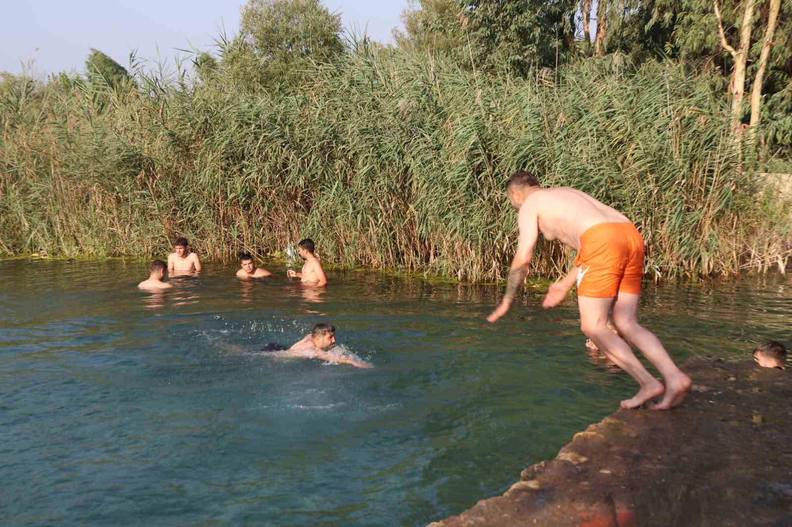Adana’da gençler bunaltan sıcakta gölette serinledi