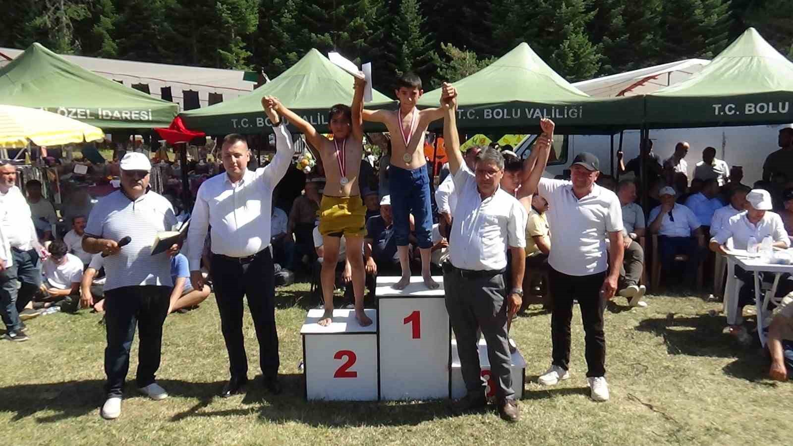 Yayla bayramında g&uuml;reşte birinci olan minik sporcu k&uuml;rs&uuml;ye &ccedil;ıkarken ayakkabılarını &ccedil;ıkardı
