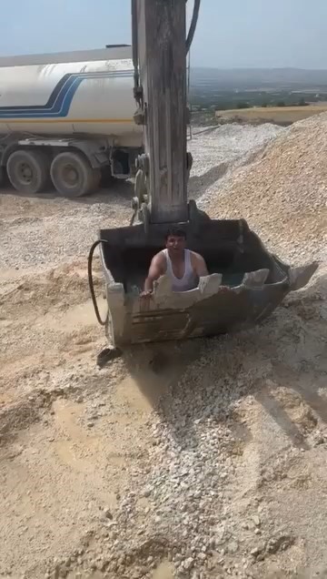 Sıcaktan bunalan işçiler kepçeyi havuza çevirdi