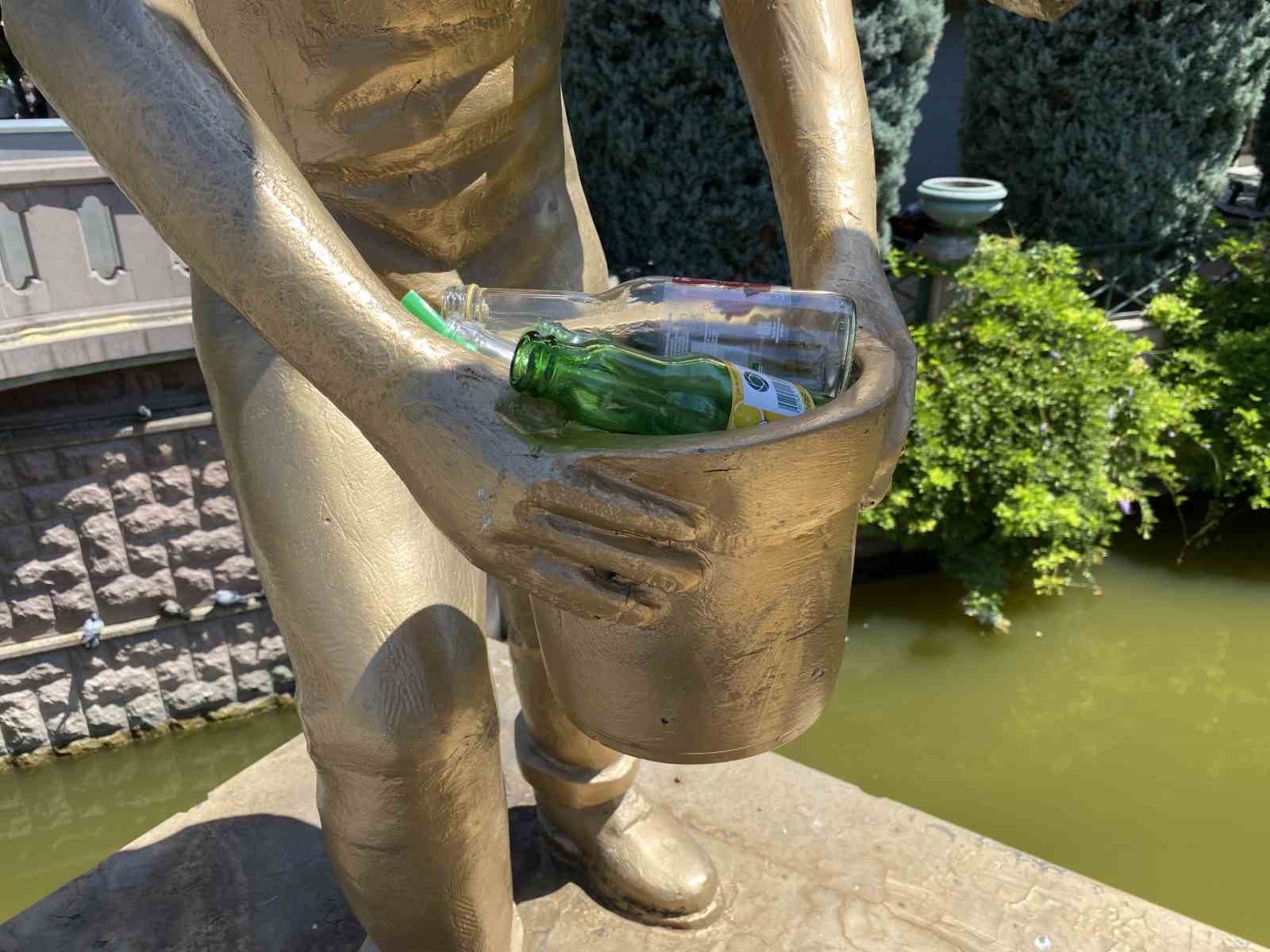 Heykelin elindeki kovayı çöp kutusuna çevirdiler