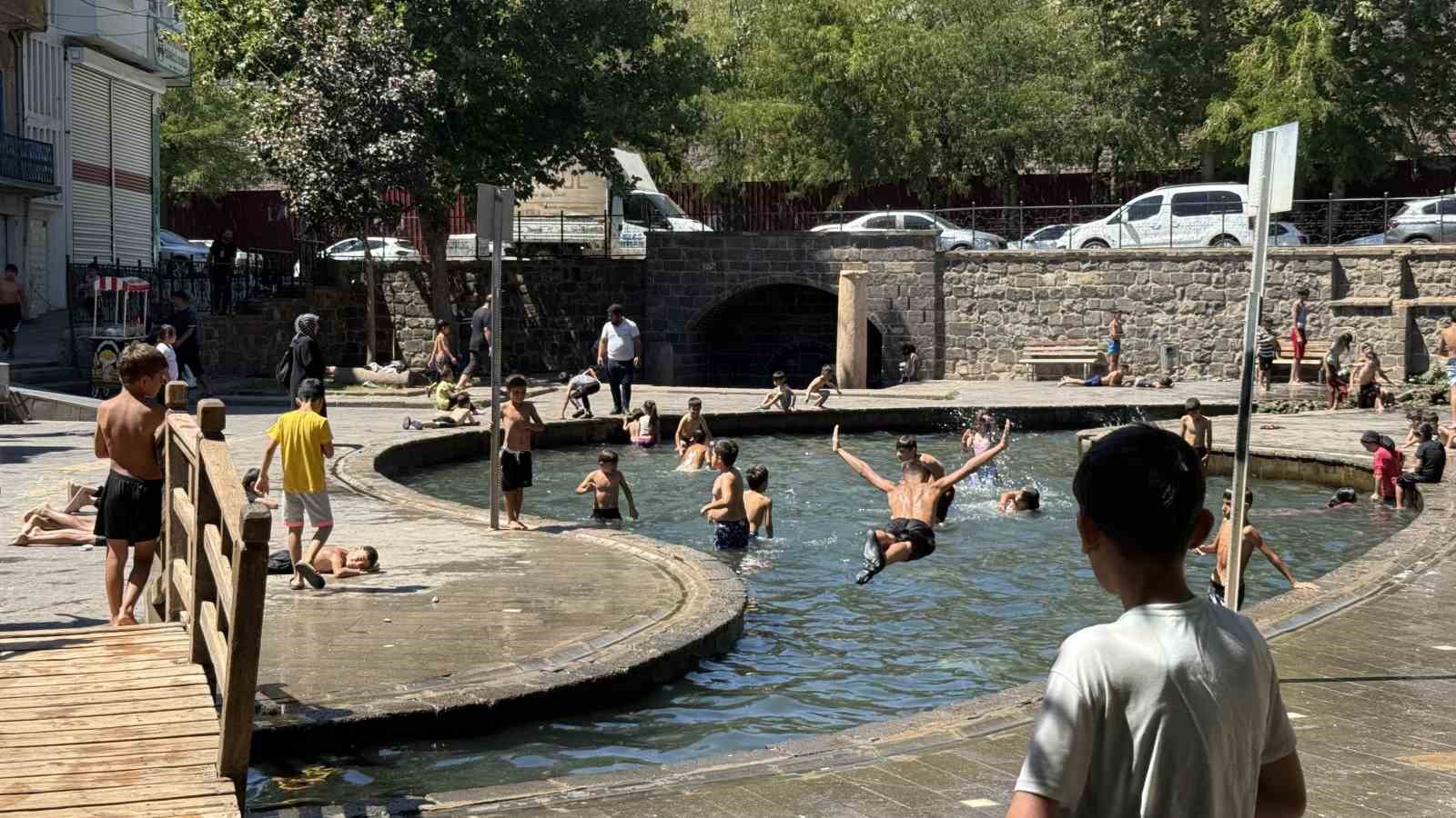 Sıcak havada kavrulan çocuklar, süs havuzunda serinliyor