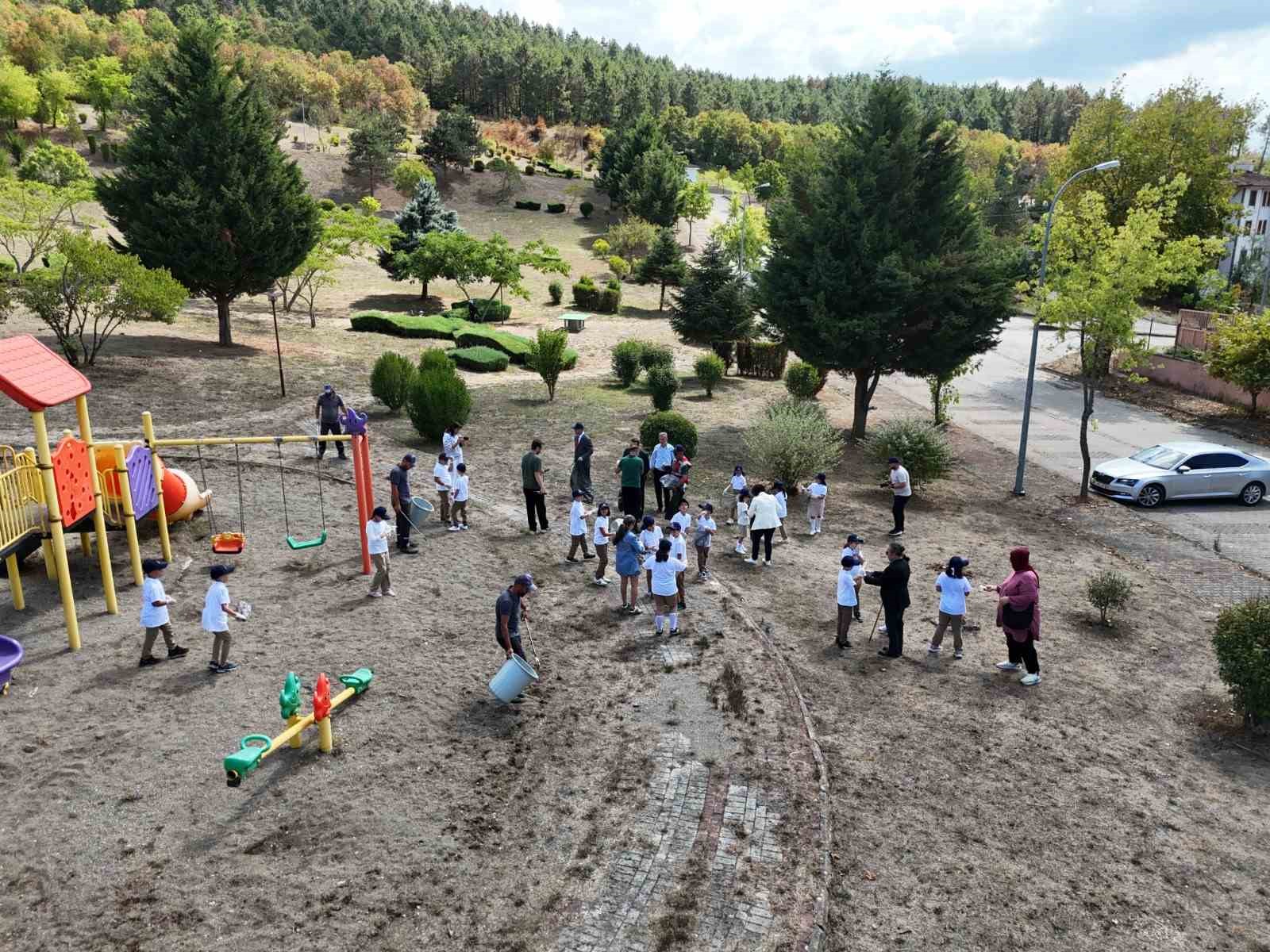 Parkı temizleyen g&ouml;revlilere &ouml;ğrenciler destek oldu
