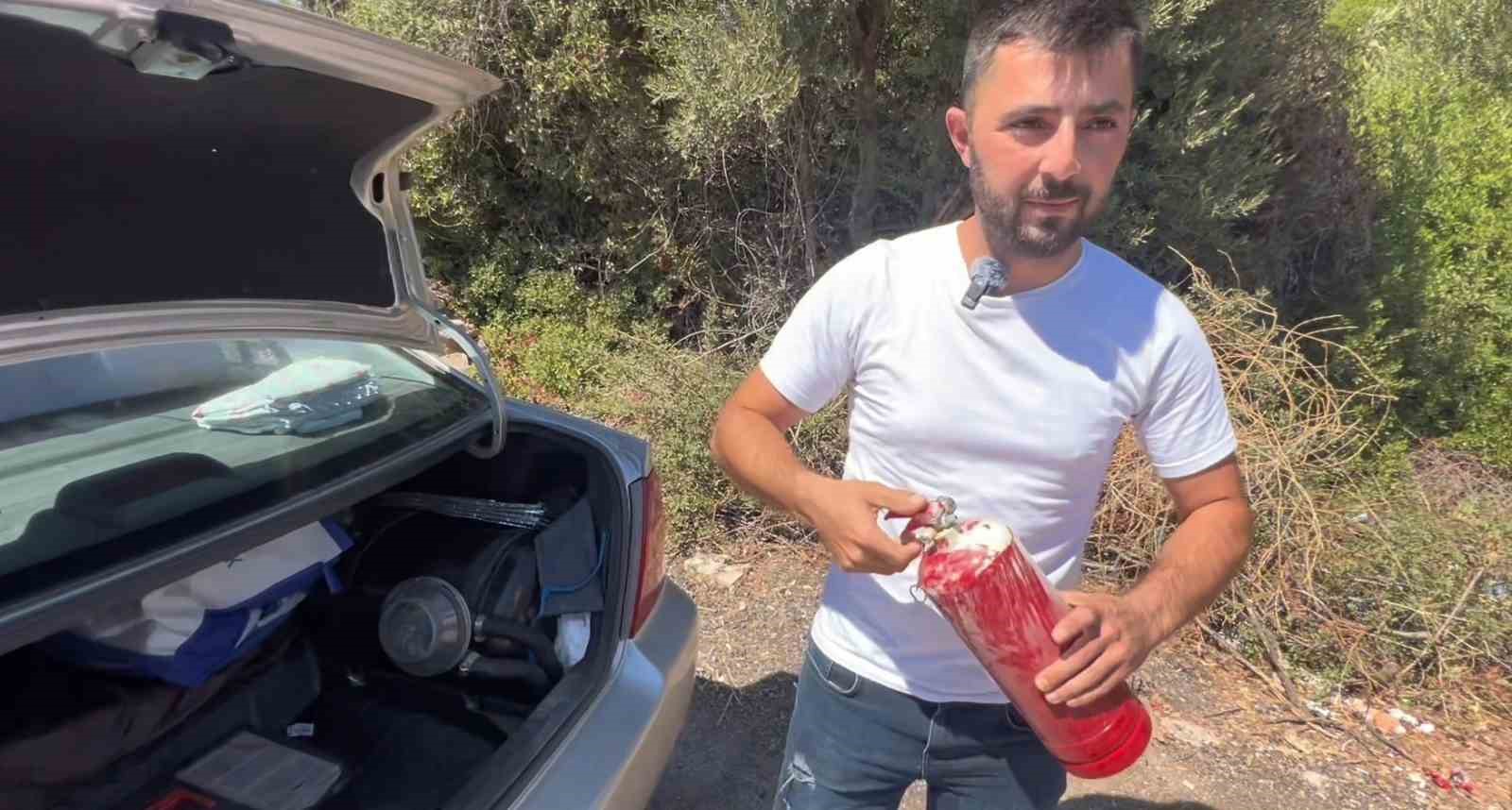 Yol kenarındaki yangını g&ouml;ren tatilci aile alevlere yangın t&uuml;p&uuml;yle m&uuml;dahale etti
