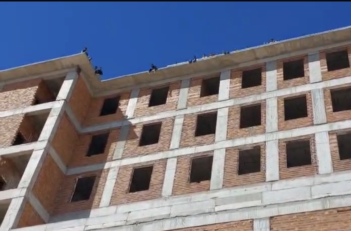 Maaşlarını alamayan işçiler binanın tepesine çıktı

