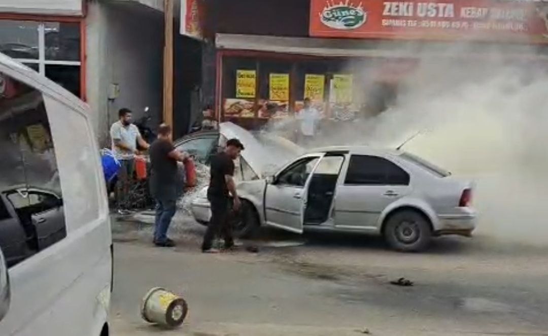 Adana’da yanan otomobili esnaf su ve yangın tüpüyle söndürdü