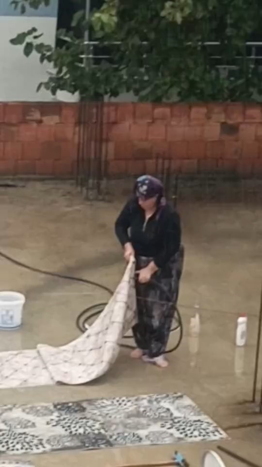 Yağmurlu havada çatıda halı yıkadı, görenler şaştı kaldı
