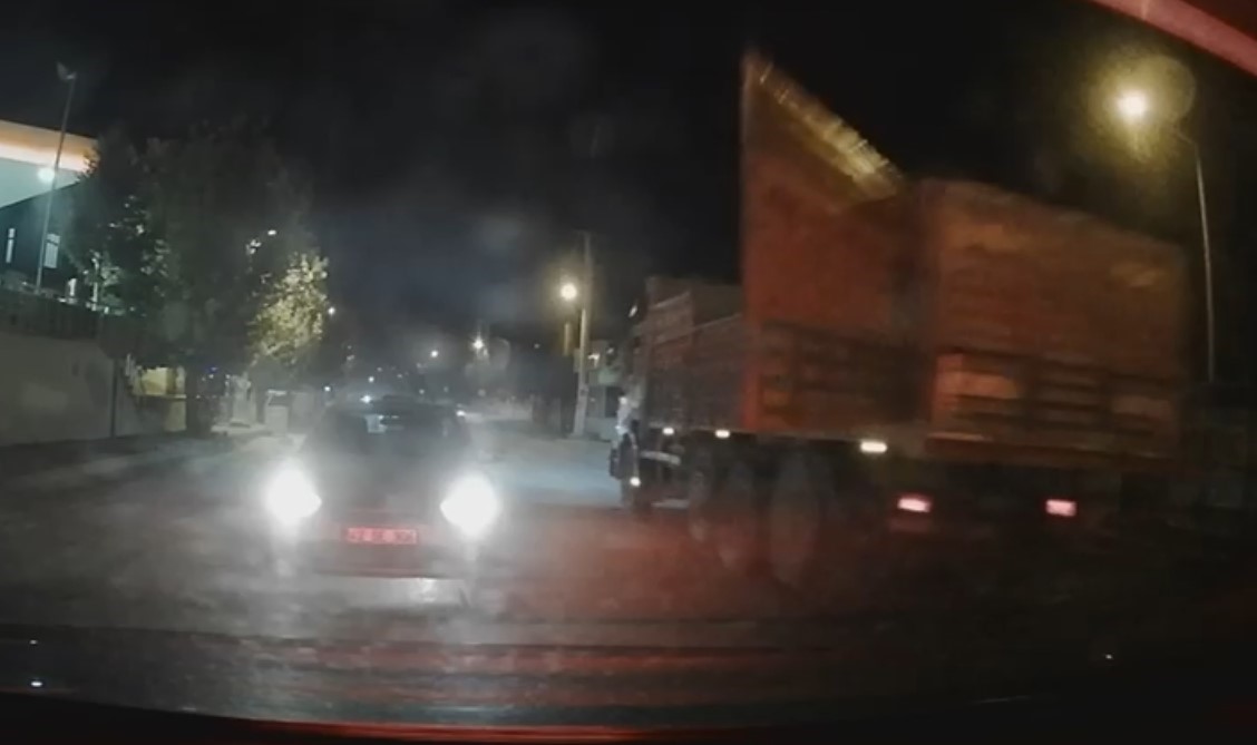 Tırın dorse kapağı a&ccedil;ıldı, kırmızı ışıkta bekleyen otomobil kıl payı kurtuldu
