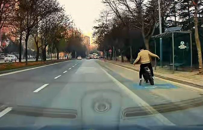 Eli cebinde bisikletle giderken araba altında kalmaktan son anda kurtuldu
