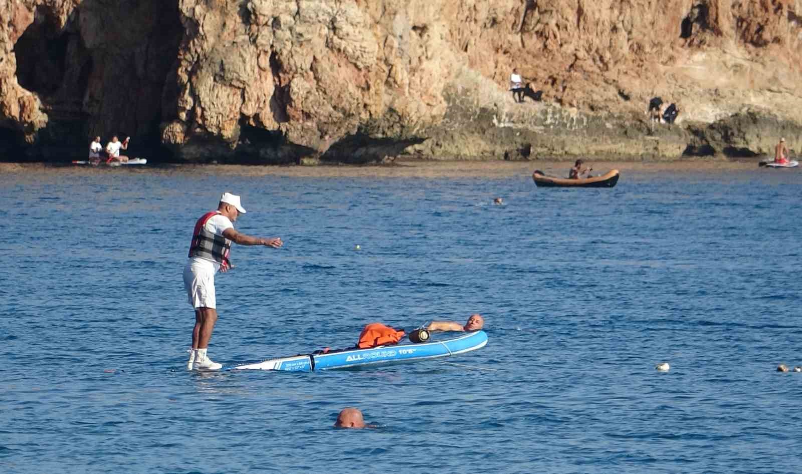 Karlı dağların gölgesinde 20 derecelik sıcak havada deniz keyfi yaptılar