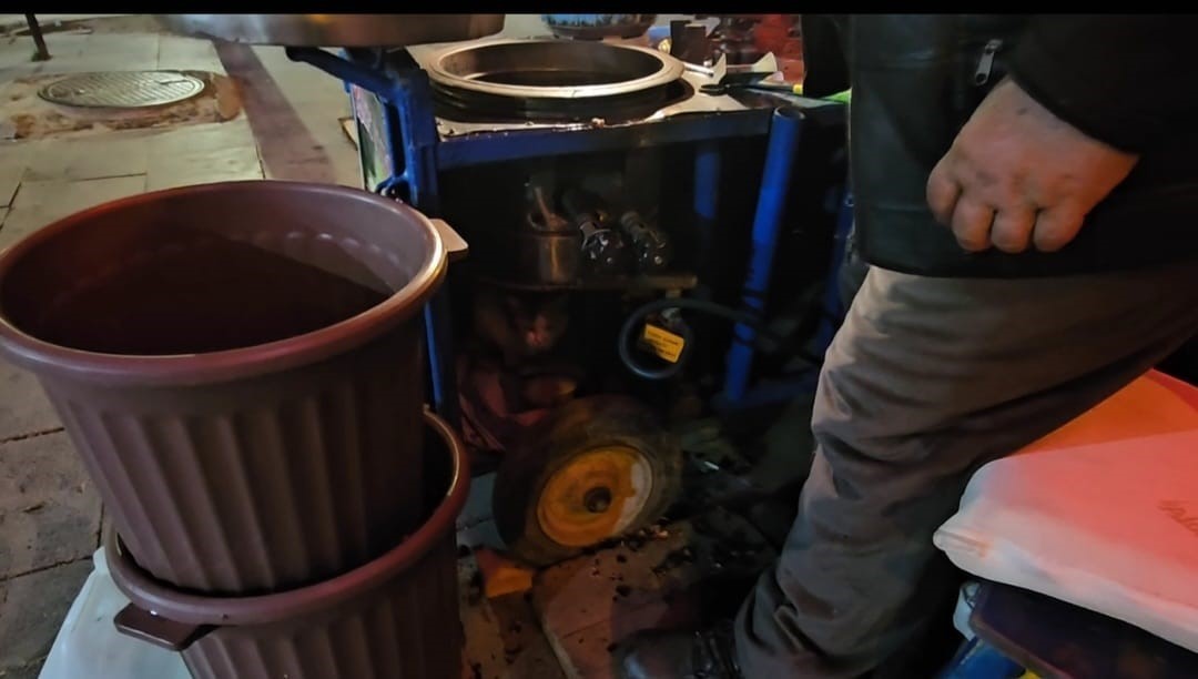 Sokak kedisine üşümesin diye kestane kazanının yanında bakıyor