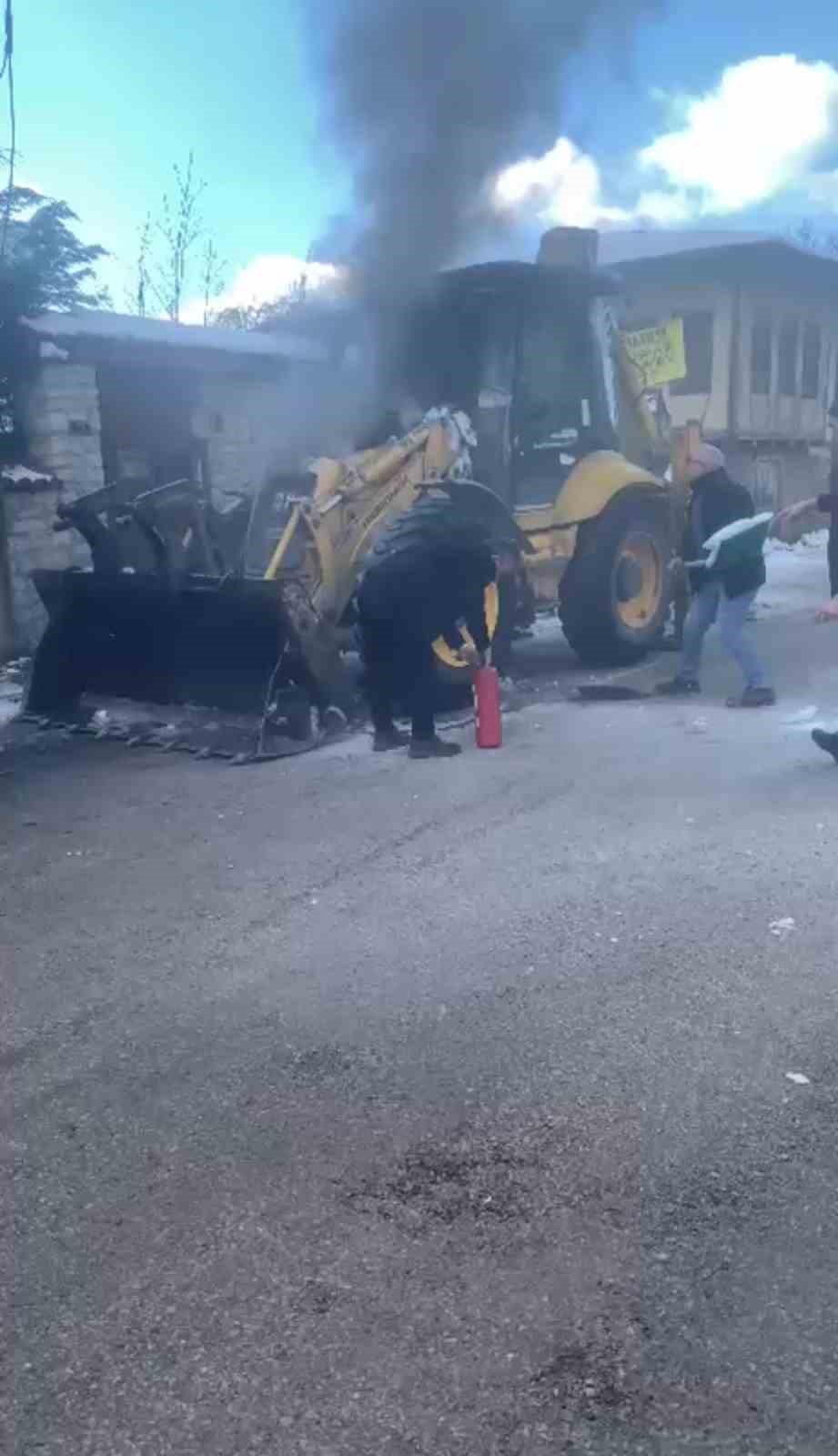 İş makinesinde &ccedil;ıkan yangını karla s&ouml;nd&uuml;rmeye &ccedil;alıştılar
