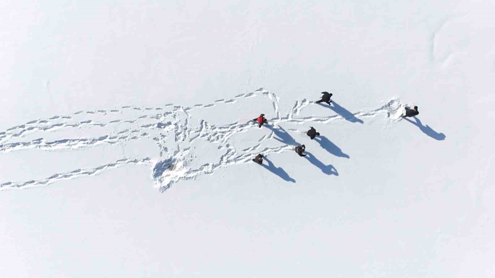 Karla kaplı dağdan donmuş g&ouml;lete botla kaydılar
