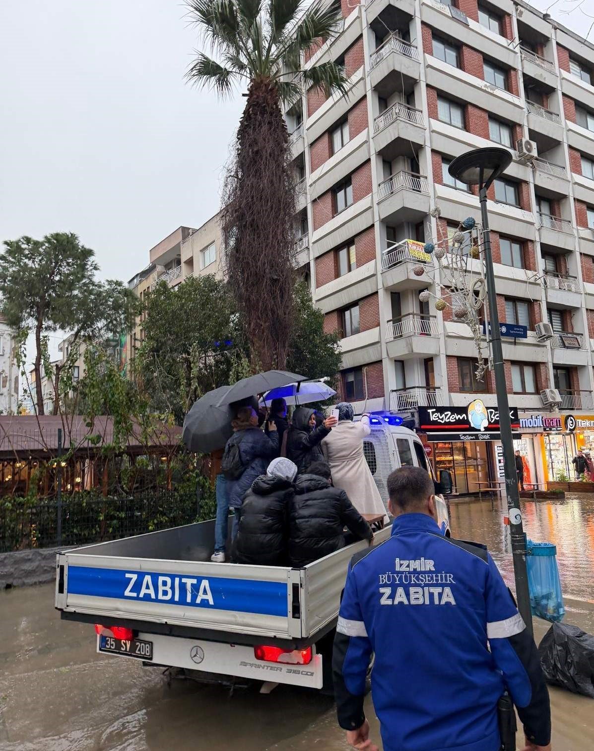 Yollar g&ouml;le d&ouml;nd&uuml;, mahsur kalanları zabıta sırtında taşıdı
