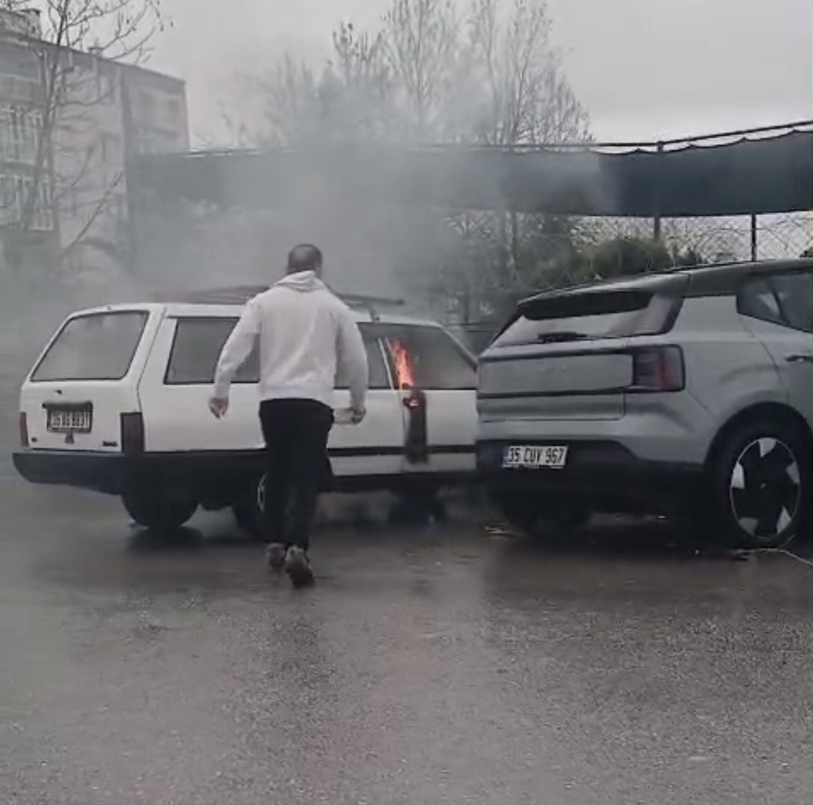 Yanan otomobile yol kenarındaki su birikintisinden doldurduğu kovayla müdahale etti