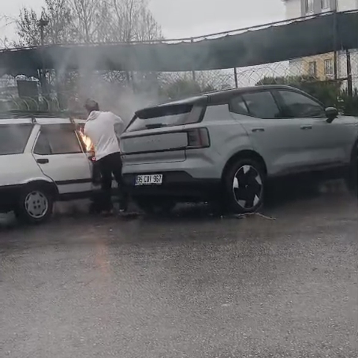 Yanan otomobile yol kenarındaki su birikintisinden doldurduğu kovayla m&uuml;dahale etti
