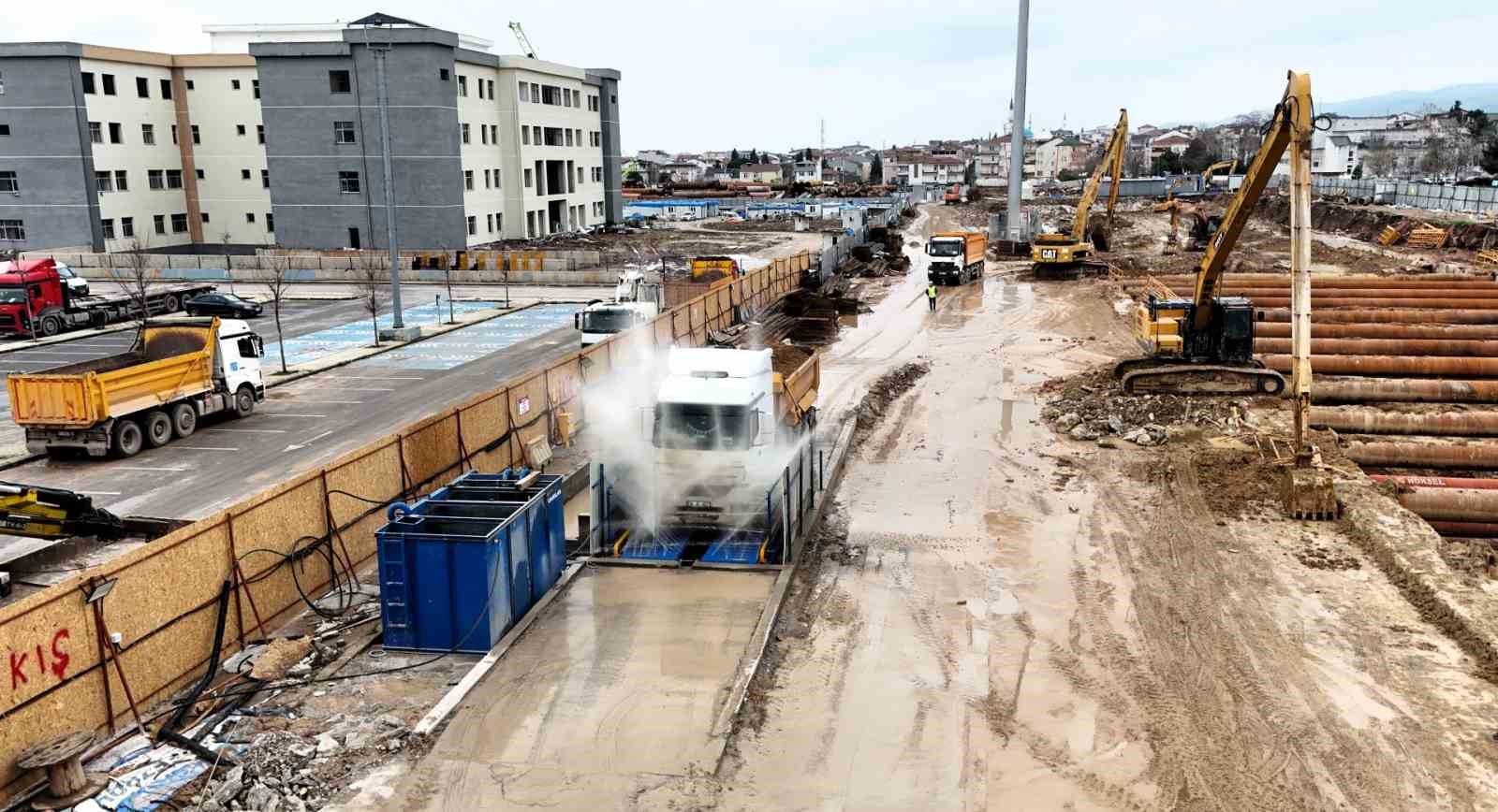 Metro şantiyesinden &ccedil;ıkan ara&ccedil;lar temizlendikten sonra trafiğe karışıyor
