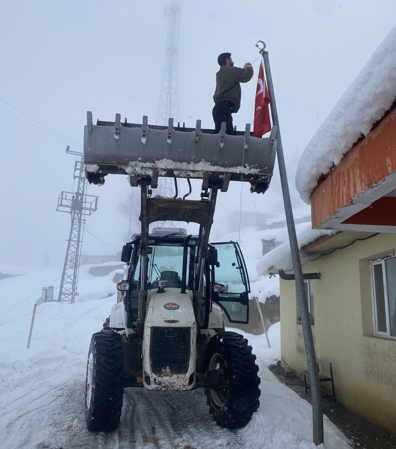 Düşen bayrağı kepçenin ağzına çıkarak yerine taktılar