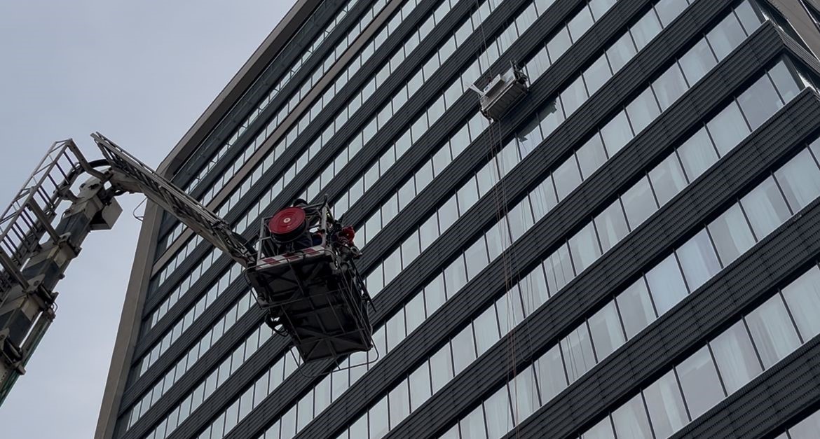 Dış cephede cam silerken asans&ouml;r sistemi arıza yapınca mahsur kaldılar: İtfaiyenin m&uuml;dahalesiyle kurtarıldılar
