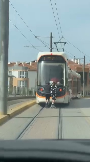 Tramvayın arkasına tutunan patenli &ccedil;ocukların tehlikeli yolculuğu
