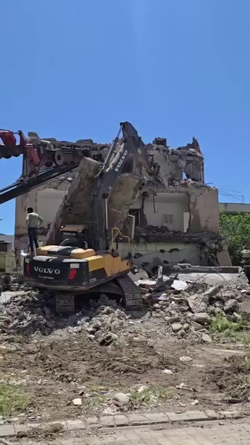 Yıkım sırasında beton bloğu iş makinasının &uuml;zerine d&uuml;şt&uuml;
