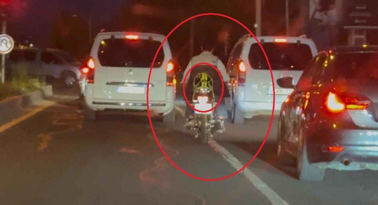 Motosiklet sürücüsü trafikte kaskı başına takması yerine arkasına bağladı