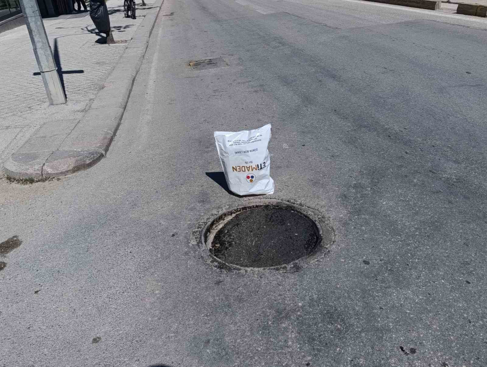 Çöken rögar kapağını gören vatandaş poşetle önlem aldı