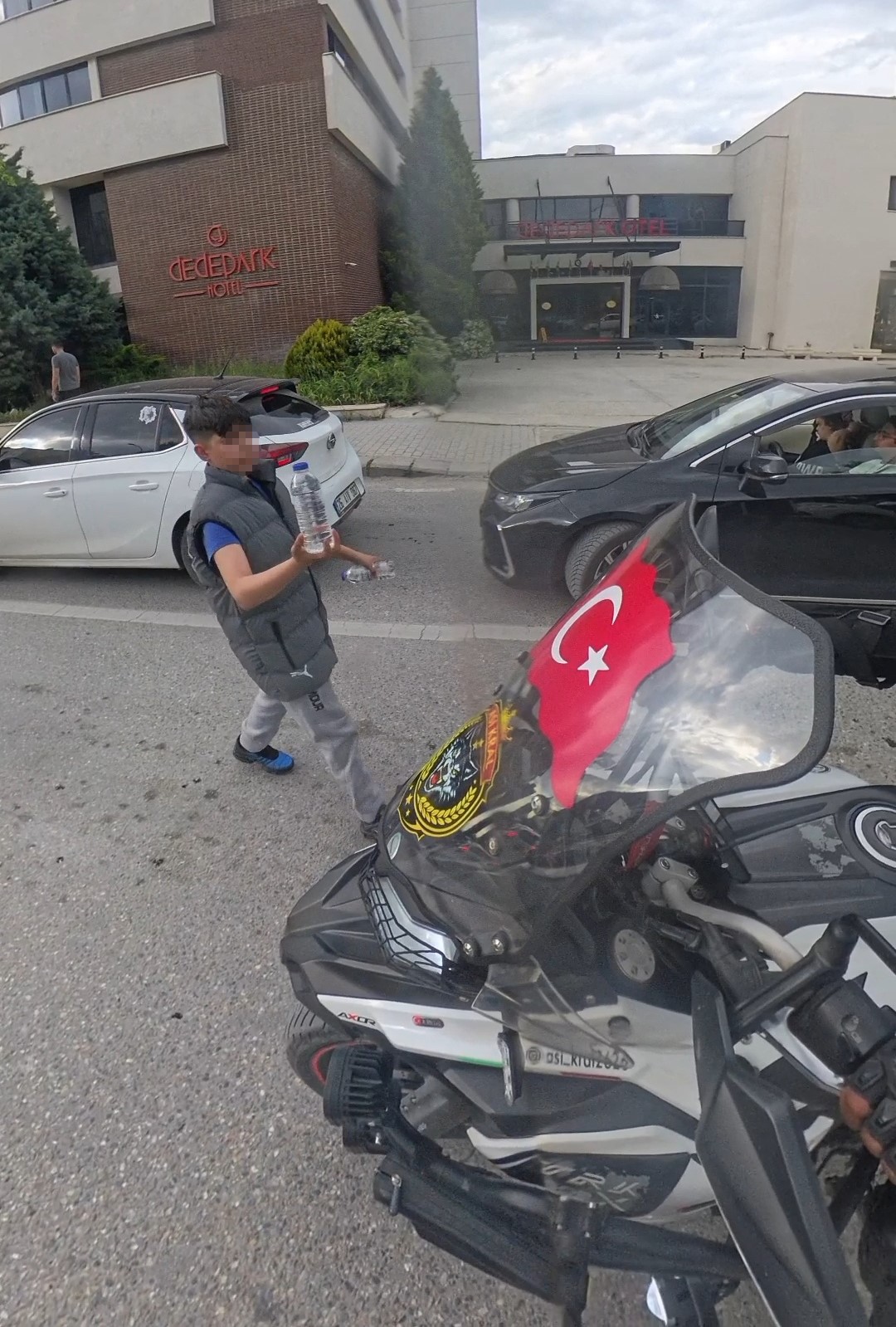Su satan çocuk, camında Türk bayrağı olan motosikletliye su hediye etmek istedi