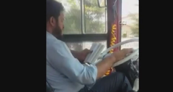Seyir halinde kitap okuyan otobüs şoförü